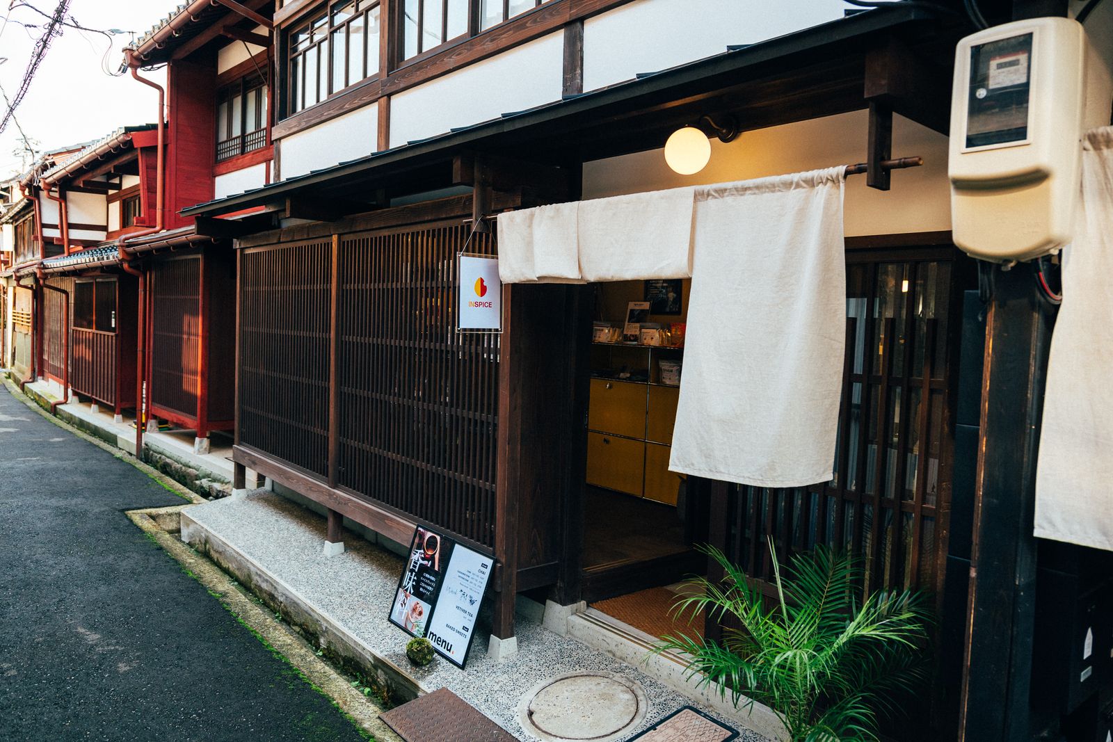 石畳の路地から見た Inspice KANAZAWA の外観と白い暖簾